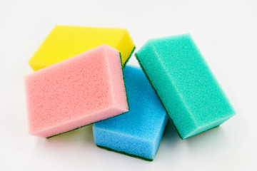 Set of multi-colored foam cleaning sponges for washing dishes, cleaning the bathroom and other household needs on a white background. Closeup