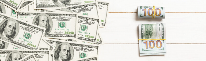 dollars currency on colored background top view, with empty place for your text business money concept. One hundred dollar bills with stack of cash