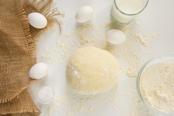 woman kneads dough with hands on the table