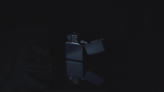 Zippo with fire extinct in a slow motion dolly on a mirror. 4K Non gradded.