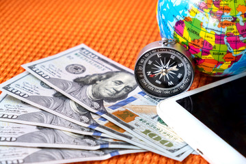 Five Hundred American Dollars, Compass, Globe of Planet Earth, Ipad on a Fabric Background Closeup. Travel  Concept.