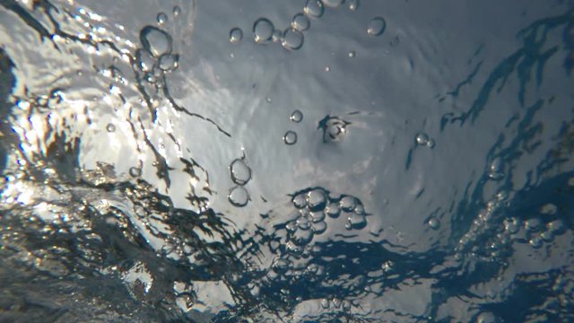 Underwater vision of drowning with panic gesture and production of numerous bubbles emitted by the person struggling in the water