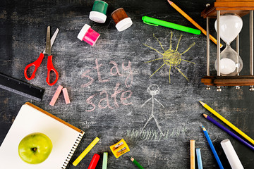Background of dirty chalkboard. School concept with stationery supplies. Concept of self-isolation in an epidemic and pandemic