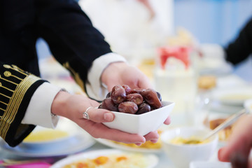 Muslim family having Iftar dinner eating dates to break feast