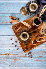 Blue background with coffee cups, coffee beans, ground and coffee-pot, retro style toned with copy space, top view