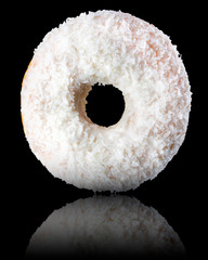 Glazed donut with sprinkles on a black background rotated in three quarters