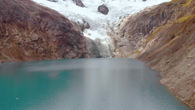 Fly over Arhuaycocha lake, in the santa cruz trek in huaraz, peruvian andes, medium shot view of the glacier, global warming effects.