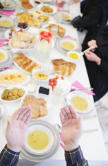 traditional muslim family praying before iftar dinner