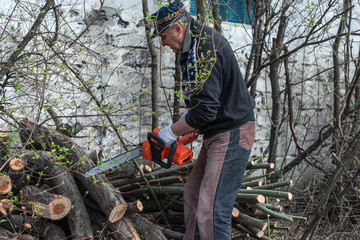 Obraz premium Elderly man is engaged in a hobby of construction and work in the yard.