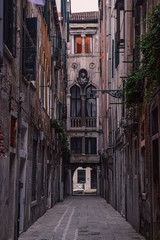 Fototapeta na wymiar Ancient stone houses on a narrow street in Venice.