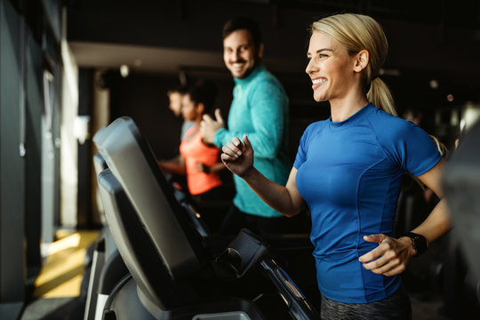 People running on treadmill in gym doing cardio workout