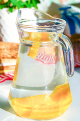 A pitcher of water filled with orange slices.