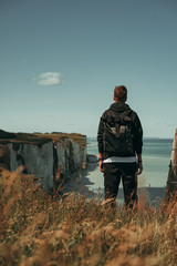 A man standing at the top of the cliff