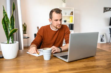 Online studying, online learning. A student guy is using laptop for watching educational video, he...
