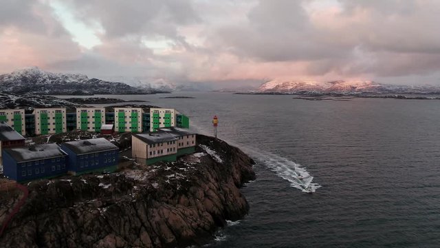 Small boats returning to the village, Greenland, aerial drone panning shot
