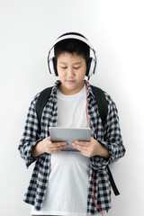 Happy Asian school boy using headphone and tablet, lifestyle concept.