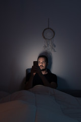 hombre mirando al movil en la cama men looking at the phone in bed