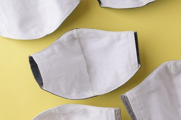 cloth mask material with white salu muslin fabric soft textile, group of objects put on yellow...
