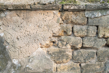 Old cracked stone wall with scratches visible stones