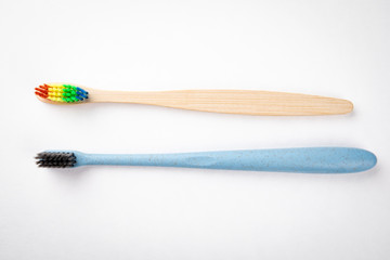 Plastic and bamboo toothbrushes on a white background