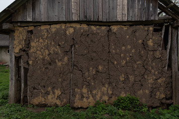  Old clay wall of clay and wood huts of a mazanka mud hut, cracked
