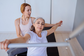 pregnant woman pilates reformer cadillac exercise workout with personal trainer