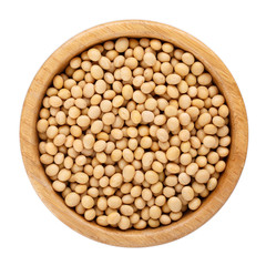 Dried soybeans in wooden bowl isolated on white. Top view.