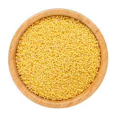 Dried millet in wooden bowl isolated on white. Top view.