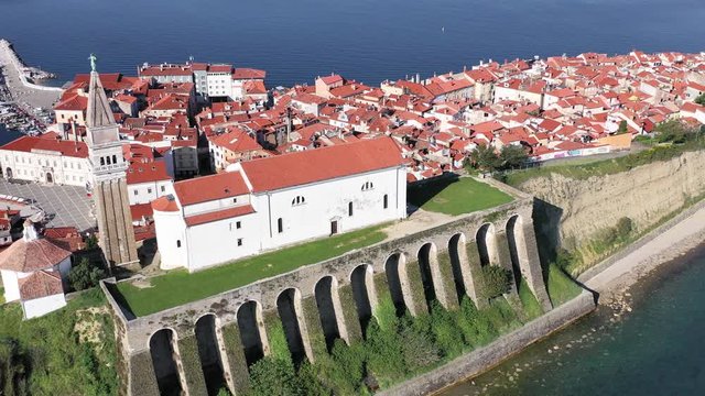 High aerial drone view of parish of Piran and coastal village of red roofs, Slovenia