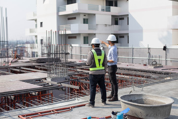 Engineers and workers on the construction site. He is inspecting the construction of a large building.