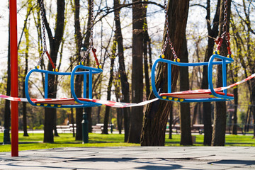 Restriction tape on children swings during state of emergency due to COVID