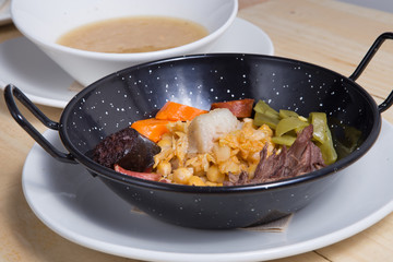 Cocido madrileno, chickpea and pork stew. Plate, food.
