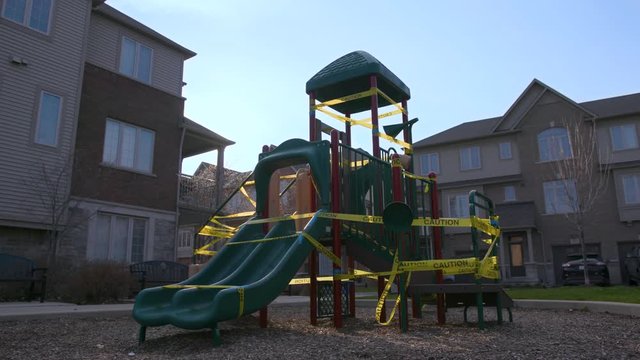 Establishing shot of a playground taped off with caution tape surrounded by residential homes