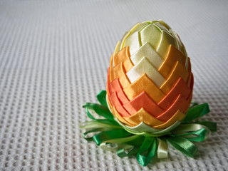 Easter decoration, colorful egg decorated with textile material, on a light background