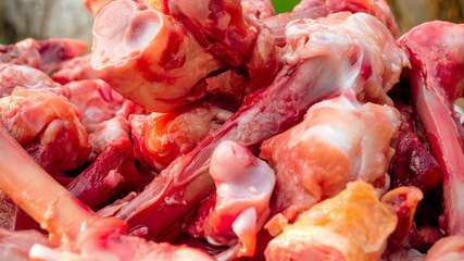 Many raw chopped gnawed chicken bones in heap lie on the table. Eating poor people or eating for dogs. Selective focus. Close-up.