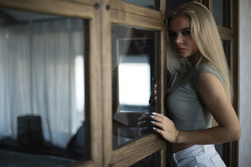Fototapeta na wymiar girl in a loft interior, modern house, windows, wall. young adult posing