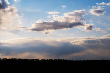 Beautiful cloudy evening sky over a field at sunset
