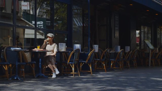 Young attractive woman in a cafe in Paris outdoors