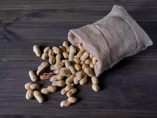 Peanuts in cloth sack on rustic table