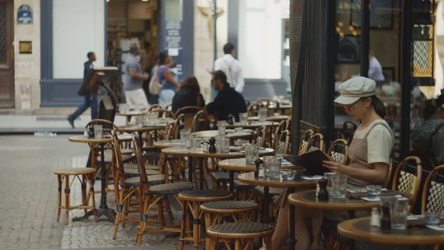 Young woman with a menu in a cafe. Paris, France