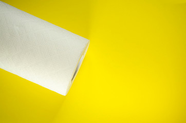 Toilet paper top view. Paper towel roll on the yellow background. Hygiene stuff for everyday. Banner template with body care products and copy space. Selective focus