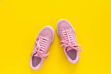 Pink nubuck sneakers isolated on a yellow background, seasonal shoes for walking and sports, top...