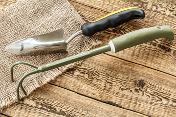 Garden tools on sackcloth and wooden boards.