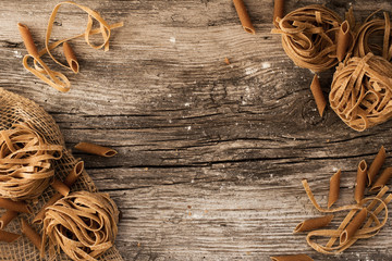 pasta on a wooden table - homemade pasta lying on a wooden, rustic table.