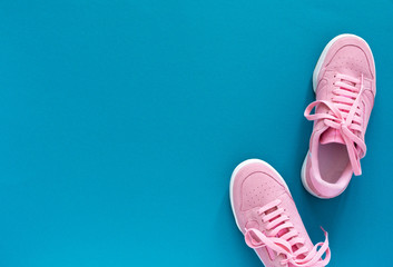 Pink nubuck sneakers isolated on a turquoise blue background, seasonal shoes for walking and...