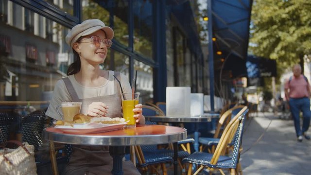 Happy woman having breakfast in a cafe in Paris, France