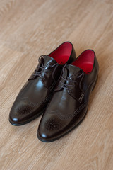 Brown shoes for men on a wooden background.