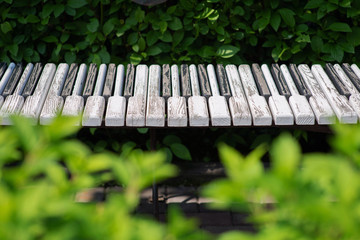 Piano-shaped bench. Creative landscape design. Old cracked keys