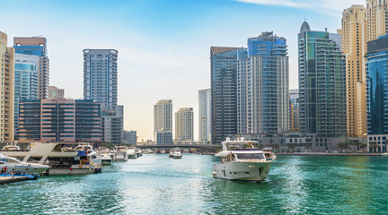 Dubai Marina skyscrapers on background and luxury yacht in water canal, Dubai, UAE.