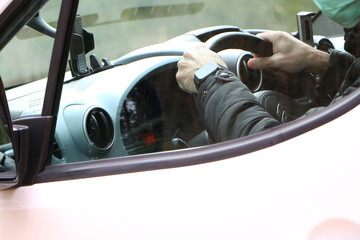 Health concept - White man driving a car in a protective mask to avoid infection with the virus.